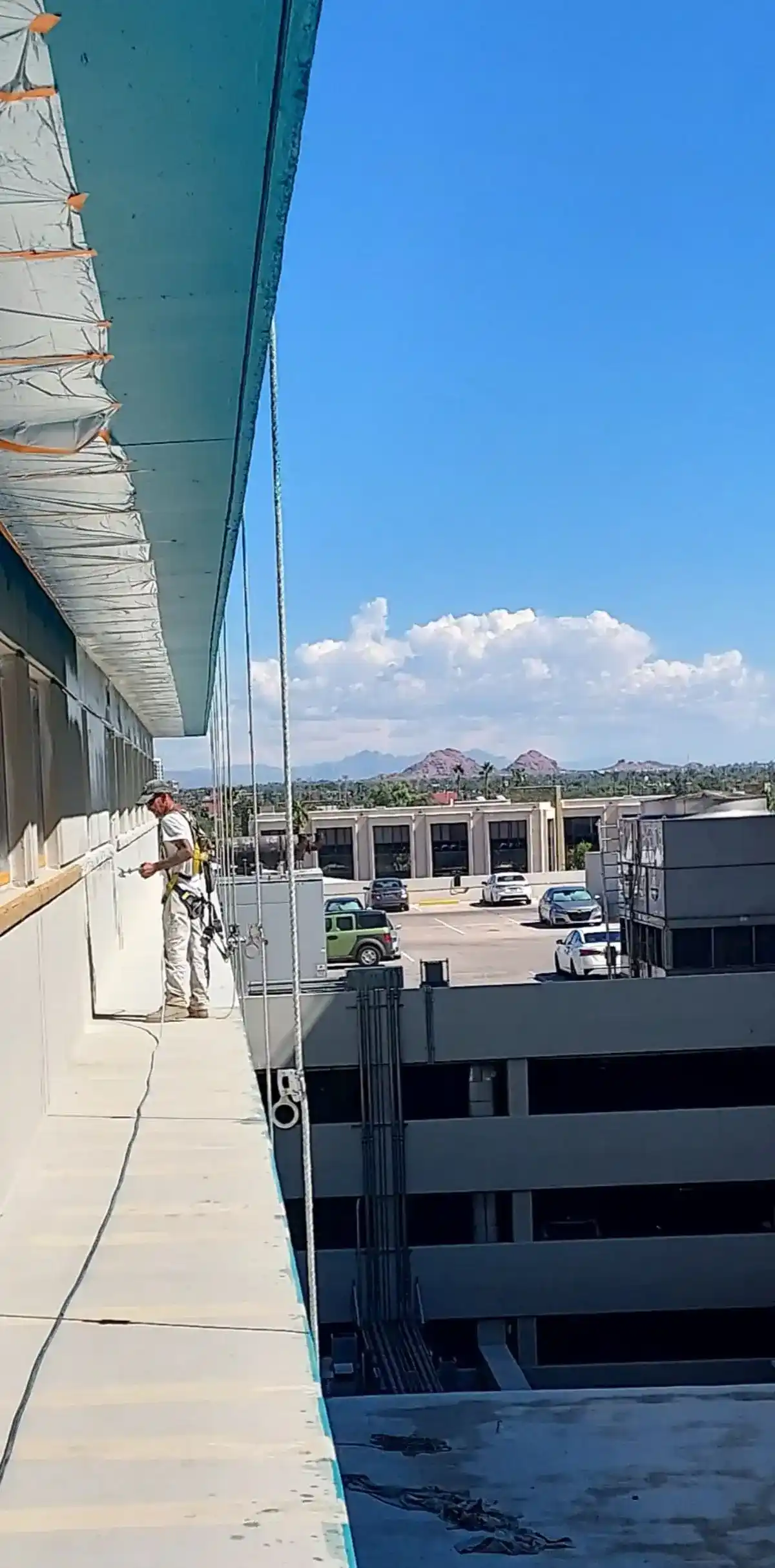 on the job Ghaster Painter working on the exterior of the building