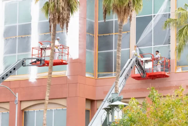 A professional painter working on exterior painting for a building.