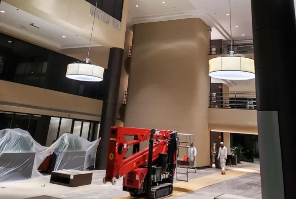 Painters preparing to paint the interior of a commercial building, with lift equipment ready for use.