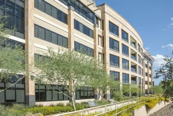 A commercial building with large, clear glass windows reflecting daylight, showcasing modern architectural design.